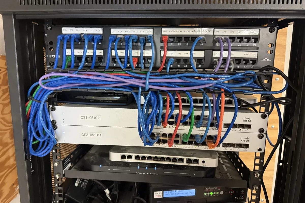 Server rack with interconnected network hardware, switches, routers, and patch panels